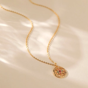 Dettaglio della collana con ciondolo bussola placcata oro 18K e gemme colorate