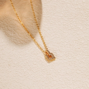 Vue macro d'un collier doré avec pendentif rectangulaire serti de zircons et chaîne fine