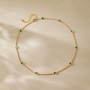 Minimalist gold necklace with ten green gemstones and adjustable lobster clasp closure