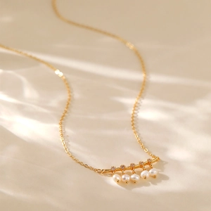 Dettaglio della collana placcata oro 18K con cinque perle e zirconi su seta