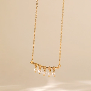 Dettaglio della collana placcata in oro 18K con cinque perle eleganti e piccoli diamanti