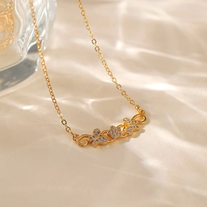 Dettaglio macro della collana placcata oro 18K con tre ciondoli a farfalla in cristallo