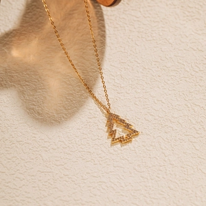 Vue détaillée du collier sapin de Noël doré avec un pavage de zircons scintillants