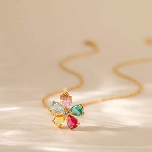 Dettaglio macro della collana floreale in oro 18K con vivaci cristalli multicolori taglio pera