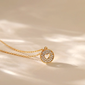 Dettaglio collana a cuore placcata oro 18K con pavé di zirconi su sfondo di seta
