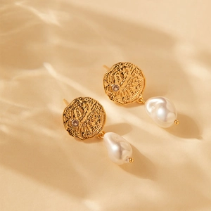 Detail of 18K gold plated coin earrings with hammered texture and baroque pearls
