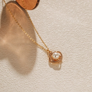 Détail d'un collier de perles plaqué or avec des cercles scintillants sertis de zircons