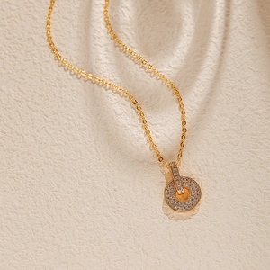 Gros plan du pendentif double cercle plaqué or avec des pierres de zircone serties