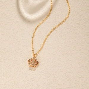 Détail du pendentif couronne dorée serti de pierres de zircone étincelantes