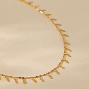 Vista macro del collar de doble capa chapado en oro de 18K con colgantes ovalados de hojas