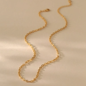 Detalle de collar gargantilla dorado con eslabones calados en forma de estrella