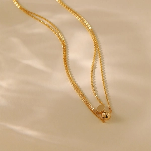 Double-layered 18K gold plated necklace featuring polished bead and oval pendants