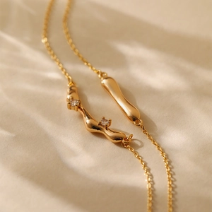 Detail of 18K gold plated double layered necklace with lava style pendants and zircons