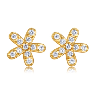 Détail de boucles d'oreilles fleur dorées serties de cristaux de zircone blancs