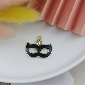 Détail d'un pendentif masque en émail noir doré avec accent étoile sur fond décoratif