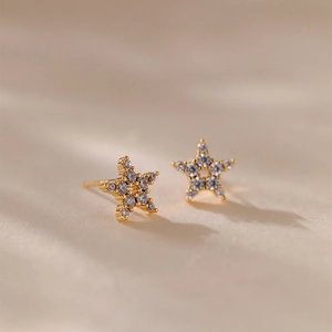 Vue macro de boucles d'oreilles étoile plaquées or avec zircons sur surface texturée
