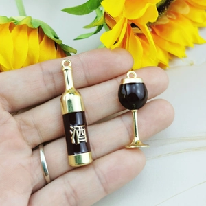 Detailed view of wine bottle and glass charms with gold accents for DIY jewelry making