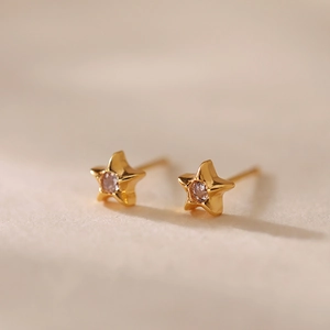 Gros plan détaillé de boucles d'oreilles étoile dorées 18 carats avec zircons