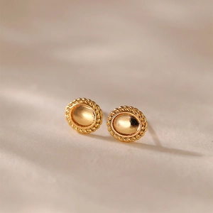 Gros plan de boucles d'oreilles ovales dorées avec texture torsadée et design rétro