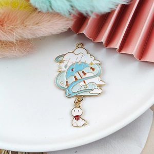 Close-up of enamel sun doll charm with umbrella and clouds on a white tray