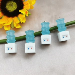 3D water dispenser charms made of resin hanging on a green plant stem for DIY crafts
