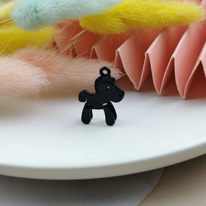 Macro shot of a black candy-colored horse alloy pendant charm for DIY jewelry