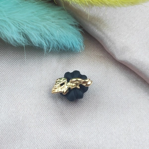Macro shot of 3D pumpkin pendant with matte black base and gold leaf decoration