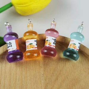Mini-Flaschenanhänger aus Harz in verschiedenen Farben auf einem Holztablett mit Tulpe