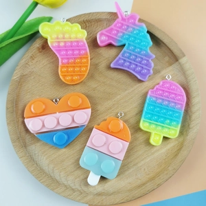 5-piece colorful silicone sensory toy charms with unicorn and foot shapes on a tray