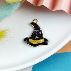 Detail of an enamel witch hat pendant with Good Witch text and a green star charm