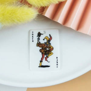 Détail macro du pendentif Joker en acrylique avec motif de carte imprimé coloré