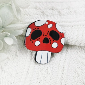 Détail macro du pendentif crâne de champignon en acrylique avec finition rouge et blanc