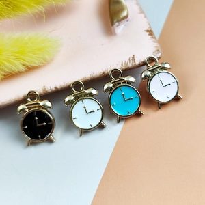 Detailed macro view of four colorful enamel mini alarm clock pendants for DIY jewelry