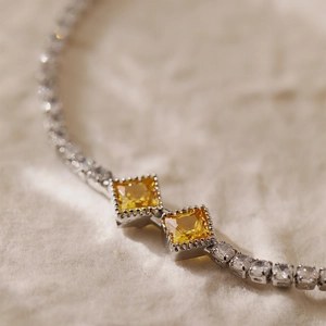 Elegant silver bracelet featuring two yellow square zircons with micro-pave white crystals