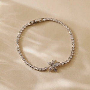 Macro shot of silver floral bracelet with cubic zirconia and safe clasp in warm lighting
