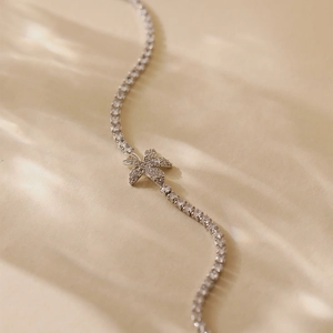 Macro detail of silver floral tennis bracelet featuring sparkling zircon stones and petals