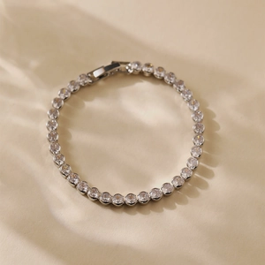 Detailed macro view of a silver tennis bracelet with cubic zirconia in a claw setting
