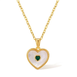 Détail d'un collier double cœur plaqué or 18 carats avec nacre et pierre précieuse verte