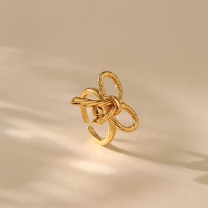 Details des goldenen Knotrings mit Seilstruktur auf minimalistischem beige Hintergrund