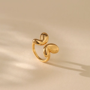 Nahaufnahme des vergoldeten geometrischen Rings mit glatten Elementen auf Beigetextur