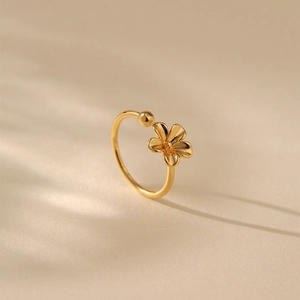 Nahaufnahme des goldenen offenen Rings mit Blumenmuster unter sanftem Licht und Schatten