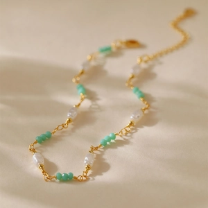 Detalle de la tobillera bohemia dorada con perlas y cuentas de cristal verde menta facetadas