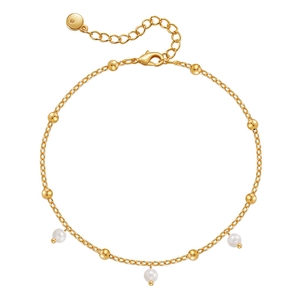 Detalle de tobillera bañada en oro con perlas blancas, borlas de gota y cierre ajustable