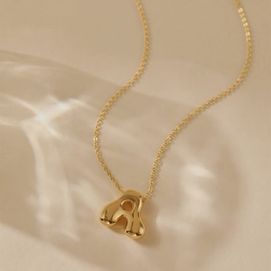 Detailed view of golden capital A letter bubble pendant with polished mirror surface