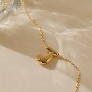 Detailed view of gold plated bubble letter J pendant with O-chain and water shadow effects