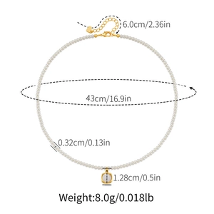 Detailoverzicht van parelketting met vierkante hanger en gouden hartverlenging