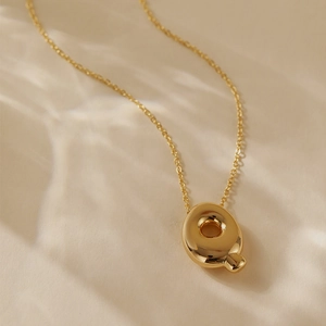 Detail of 18k gold plated letter Q balloon pendant necklace with high polish finish