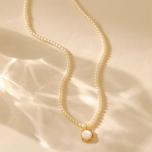 Franse retro parelketting met een geometrische vierkante gouden hanger en parelmoer