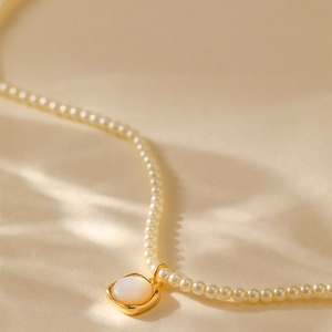 Franse handgemaakte parelketting met een geometrische vierkante gouden hanger design