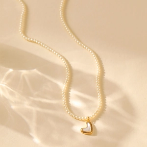 Klassieke parelketting met goudvergulde hartjeshanger en zachte waterrimpellicht